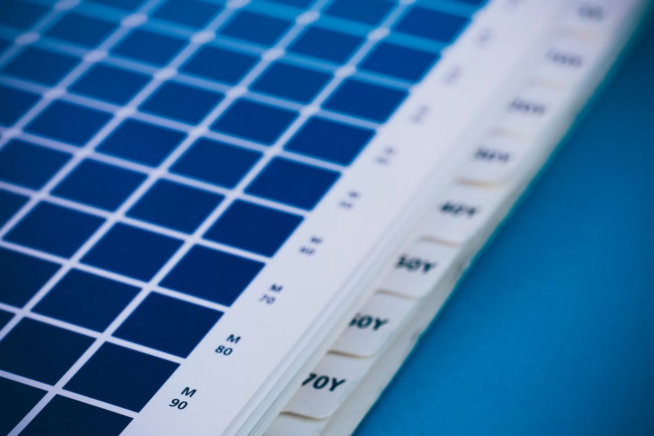 Mastering the First Impression: Your intriguing post title goes here Close-up of a blue color swatch book showing different shades and codes.